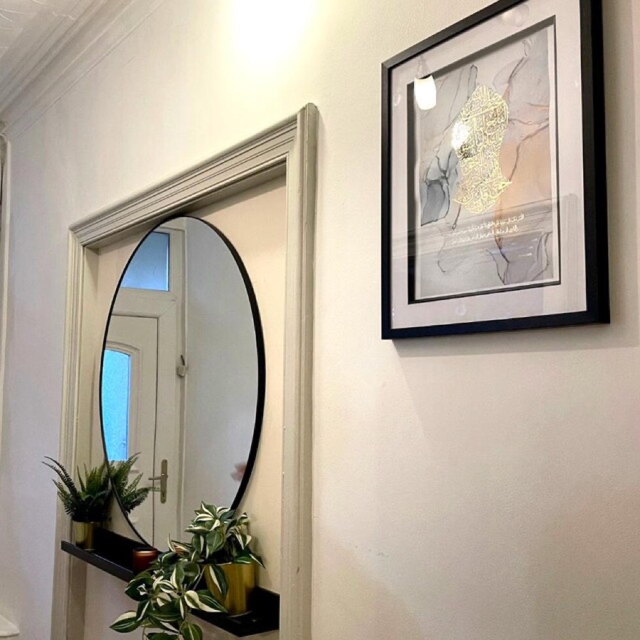Customer photo: a gold-foiled print beside a round mirror