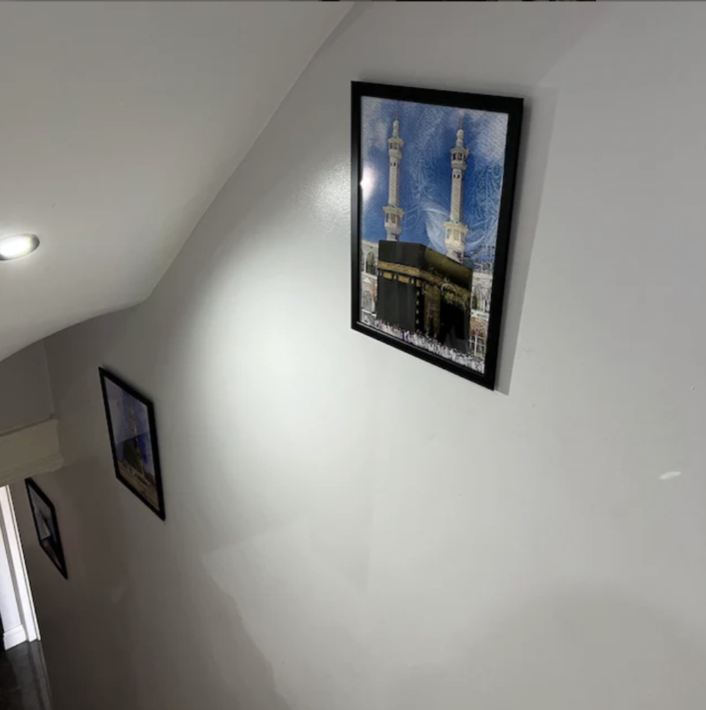 Customer photo: a print in a black frame on a stairway wall